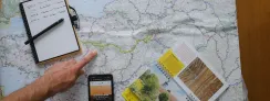 Carte, topoguide de la Véloscénie et smartphone posée sur une table