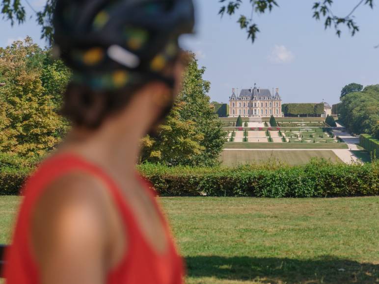 Cycliste regardant la perspective s'ouvrant sur le château de Sceaux depuis la Coulée Verte